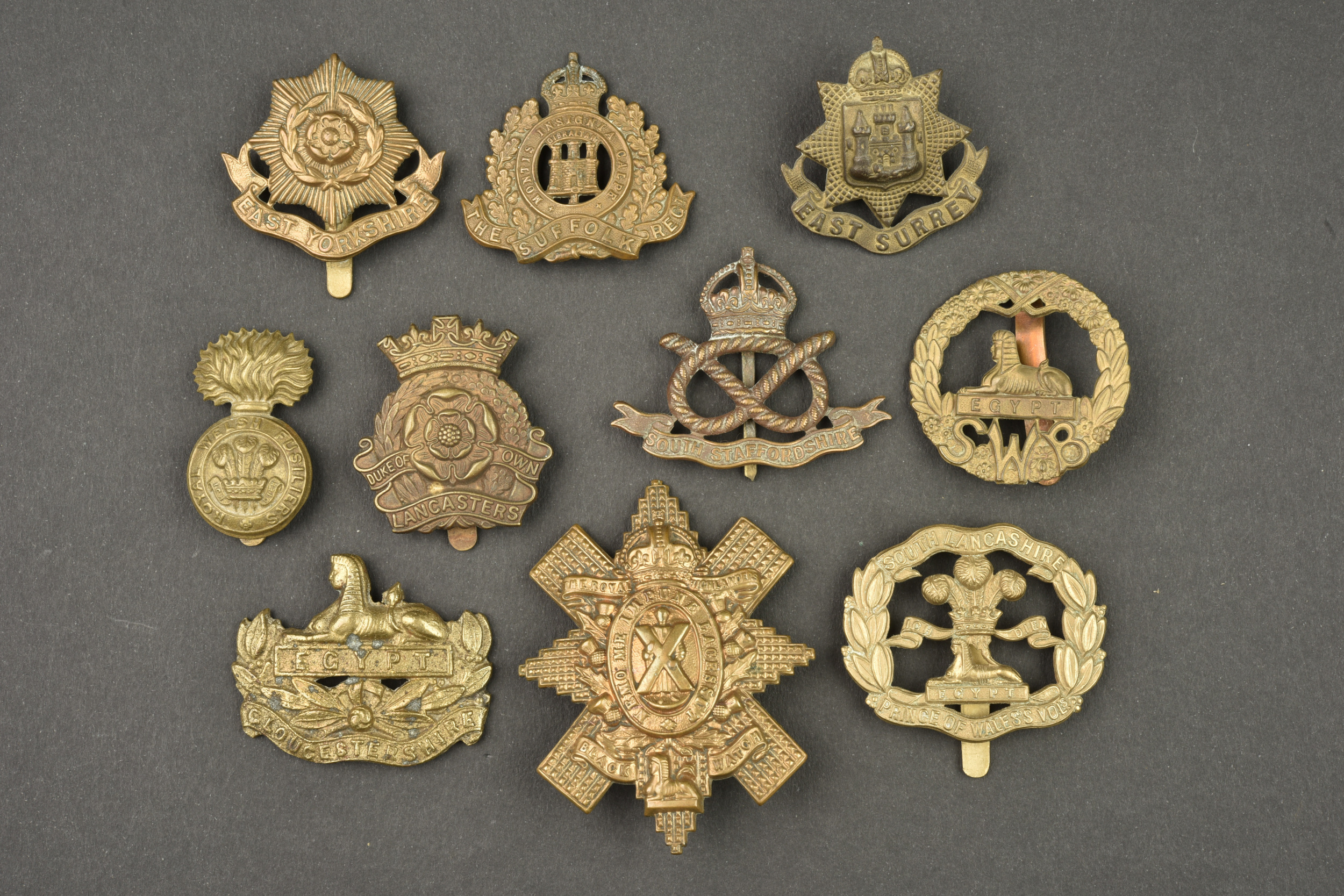 Lot de 10 cap badges anglais d'infanterie modèle economy. Lot of 10 British infantry cap badges, economy pattern — photo 1